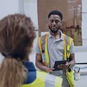 Matthew Seawright, a business graduate, speaking to an employee in a warehouse